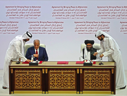 Zalmay Khalilzad and Mullah Baradar sign the US-Taliban peace agreement in the Qatari capital Doha. Credit to AFP via Getty Images