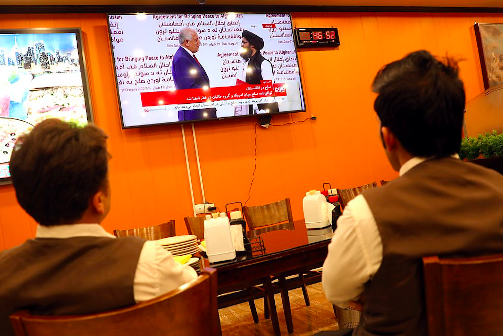 Afghans in Kabul watch a live TV broadcast at a restaurant during the signing ceremony between the US and the Taliban. Credit to Reuters