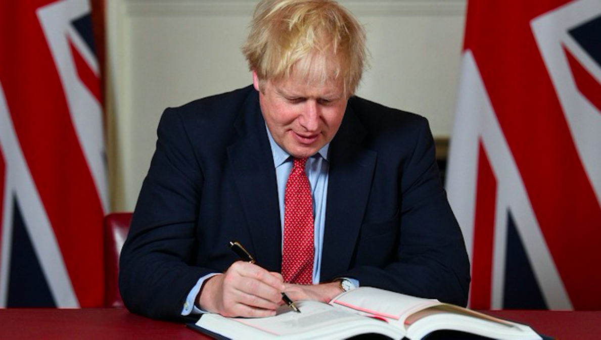 PM Boris Johnson signs the agreement. Credit to ITV