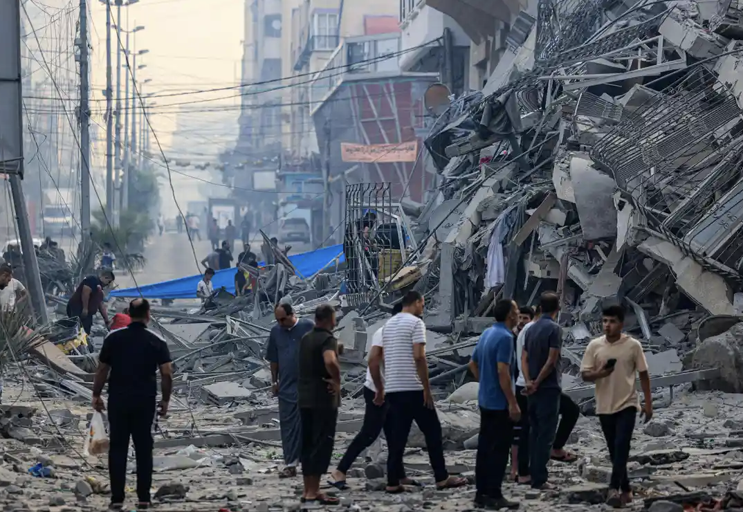 People in Gaza City after an Israeli airstrike early on Sunday. Credit to Mahmud Hams/AFP/Getty Images