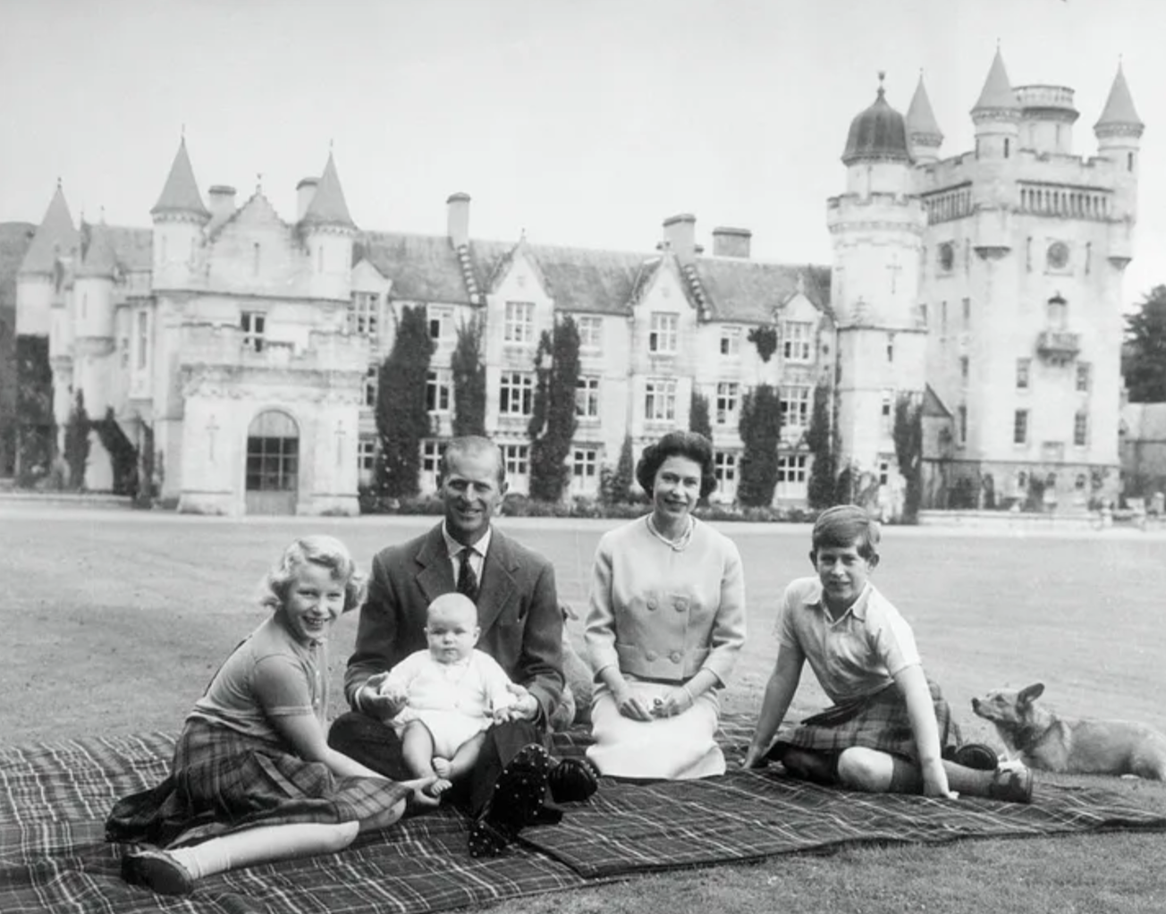 Queen Elizabeth and Prince Philip with Baby Prince Andrew, Prince Charles, and Princess Anne during a picnic on the grounds of Balmoral Castle. Credit to Getty Images