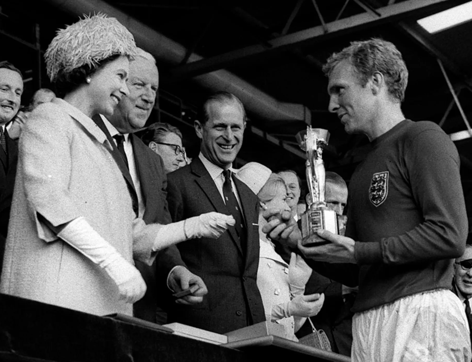 The England captain Bobby Moore holds the Jules Rimet trophy, collected from the Queen, after leading his team to a 4-2 victory over West Germany in a historic World Cup final in 1966. Credit to PA