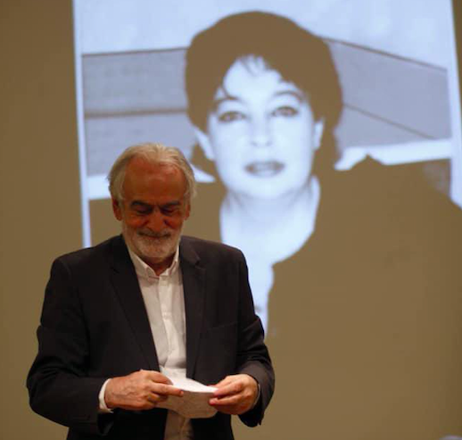 Gela Charkviani presenting his book "Nagerala". Nana Toidze, his wife, on the screen behind. Credit to Ambebi GE