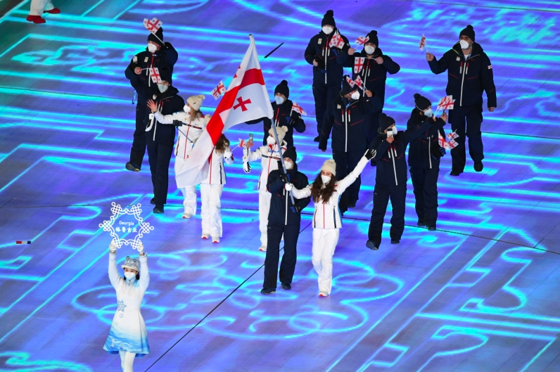 Flag bearers Nino Tsiklauri and Moris Kvitelashvili of Team Georgia lead the team during the opening ceremony of the Beijing 2022 Winter Olympics. Credit to Geonoc