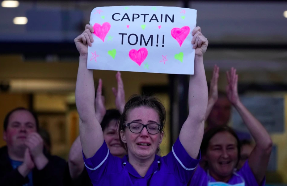 A nurse shows her love of Captain Tom during Clap for Our Carers during the first lockdown. Credit to Getty Images