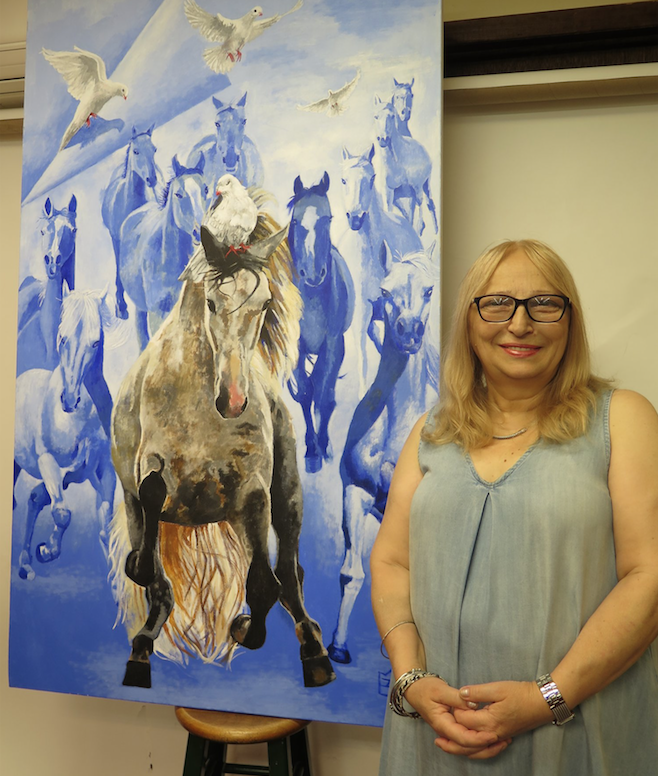 Gulnara Tsiklauri next to her painting Freedom. Retrieved from Facebook